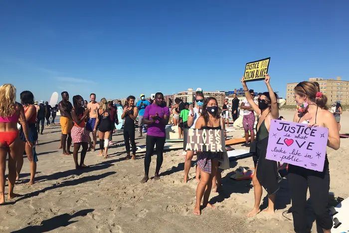 Protesters gather at Rockaway Beach holding signs in support of Black Lives Matter.